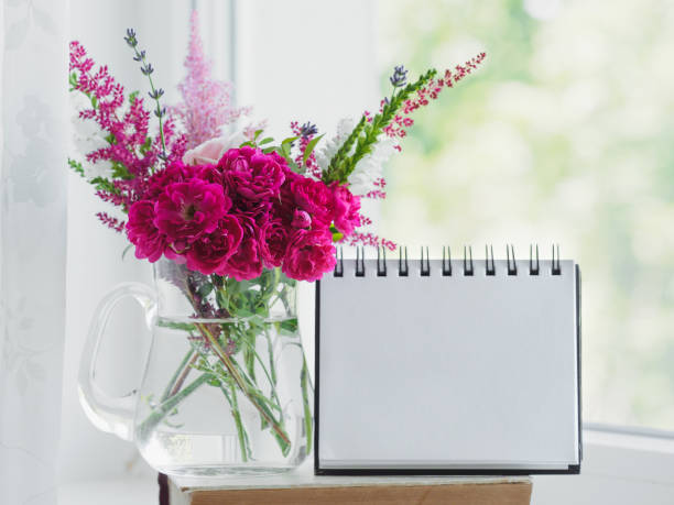 istock Bouquet of bright flowers and a blank notepad page 2039810241