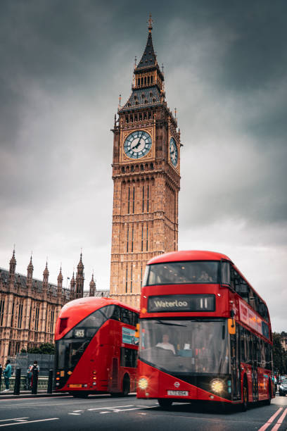 des touristes prennent des photos alors qu’un bus rouge navigue sur l’emblématique tower bridge. - semaine de la mode de londres photos et images de collection