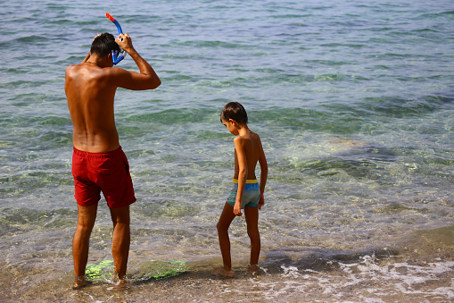 Father and son diving on sea