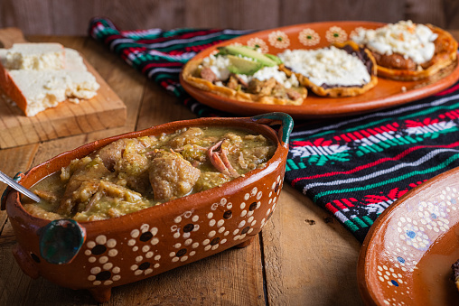 Chicharrones in green sauce, typical mexican food. Mexican food in clay pot.