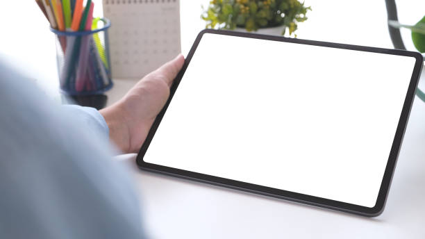 istock Close up of man hand holding digital tablet with blak screen on working table background for mock up, template 2039828872