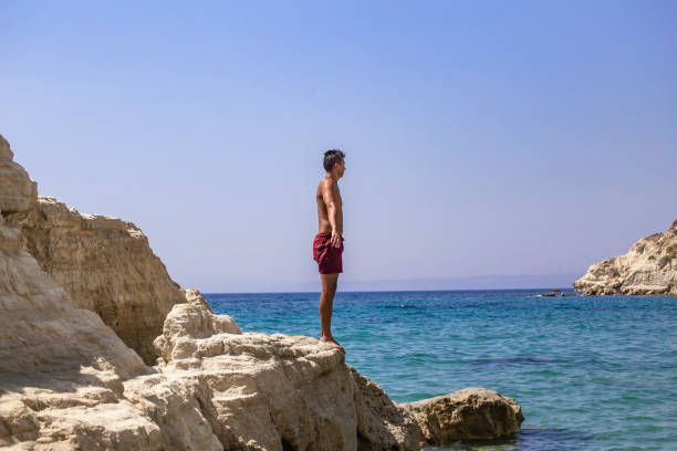 istock Man standing on top of cliff above sea 2039832818