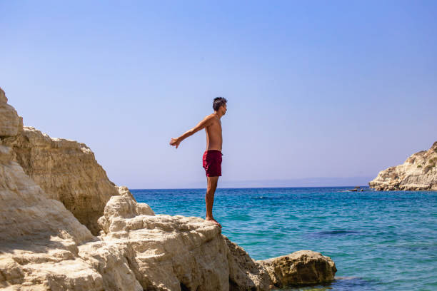 istock Man standing on top of cliff above sea 2039834985