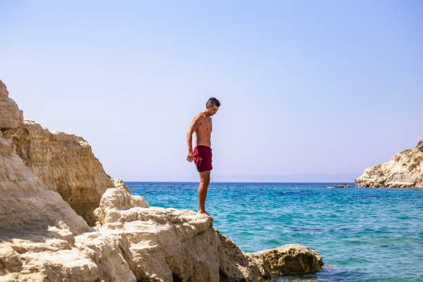 istock Man standing on top of cliff above sea 2039835523