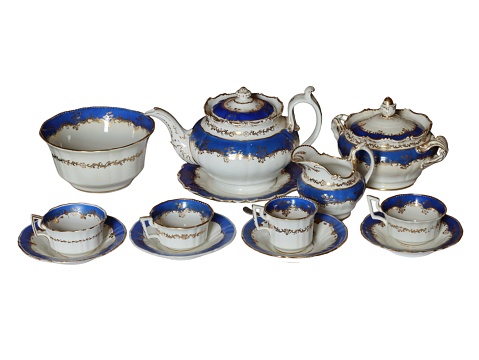 Elegant antique porcelain tea set with blue decorative elements isolated on white