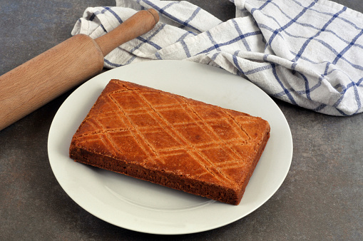Traditional Breton cake on a plate with a rolling pin and a tea towel close-up