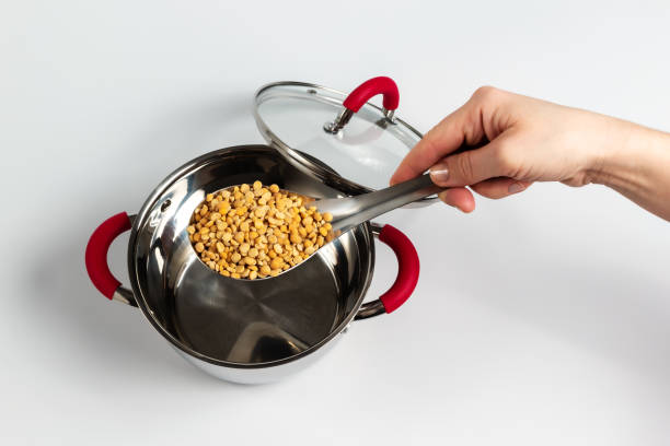 Dried yellow peas in a pouring spoon prepared for cooking soup stock photo