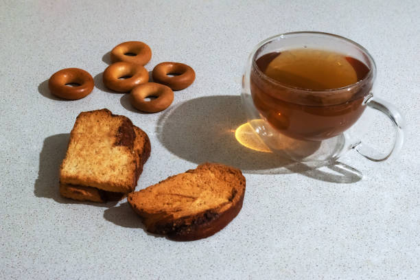 Composition with appetizing rusks (dry bagels) and a mug of tea on a light gray table stock photo