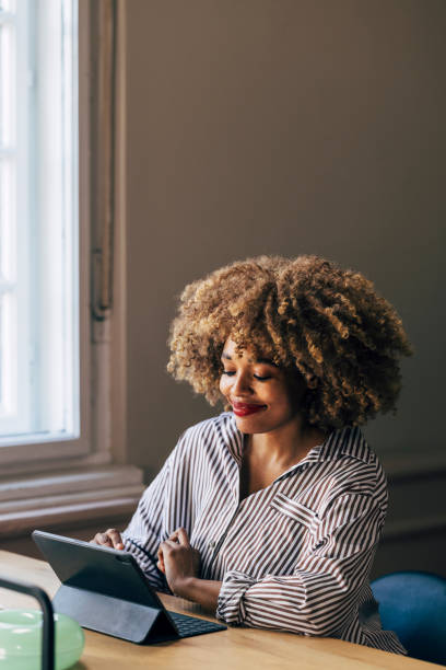 istock Smiling Woman Using Tablet in a Well-Lit Room with Positive Vibes 2039917543