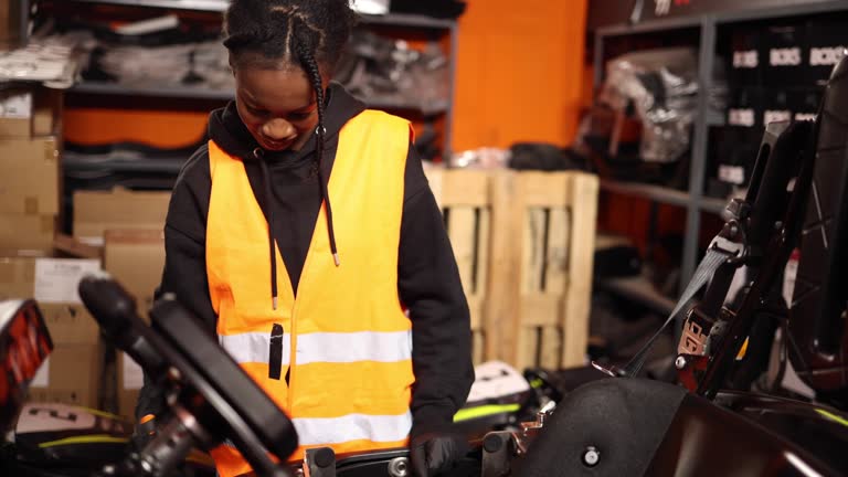 African American woman go kart mechanic repairing electric car in workshop