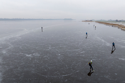 People ice skaring on the frozen Drontermeer lake near Elburg during a beautiful cold winter day on Januari 11, 2024. Ice skating on natural ice is an old tradition in The Netherlands and a popular leisure activity whenever it's cold enough for lakes and rivers to freeze over.