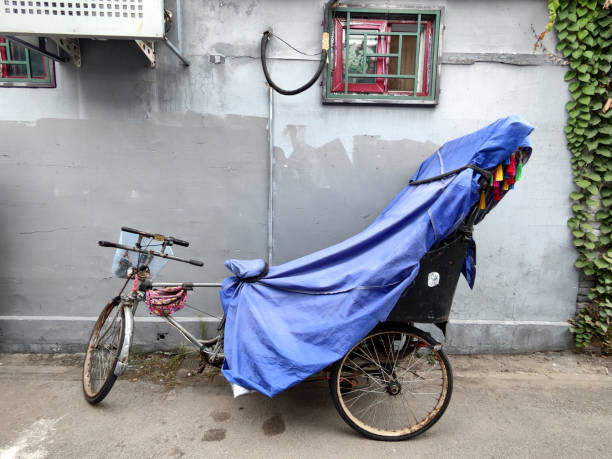 Covered pedicab at a Beijing's Hutong, a type of narrow street or alley commonly associated with northern Chinese cities, especially Beijing.\nIn Beijing, hutongs are alleys formed by lines of siheyuan, traditional courtyard residences.