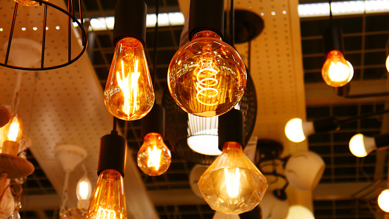Many hanging yellow glowing lamps in a store