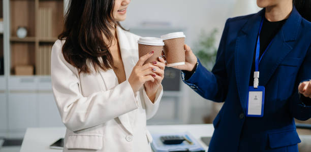 istock Two business worker standing and holding a coffee cup in modern office, successful, celebration, new project, team office concept 2039983863