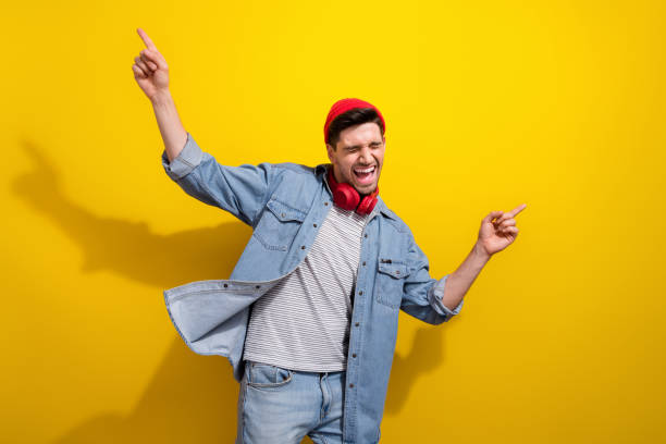 istock Photo of charming cool guy wear denim jacket having fun showing two fingers empty space isolated yellow color background 2039999585