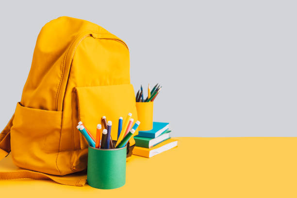 istock School supplies with books and backpack on yellow background 2040004400