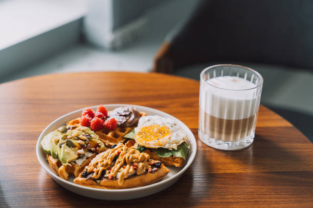 Homemade waffles with different toppings on a white plate with coffee