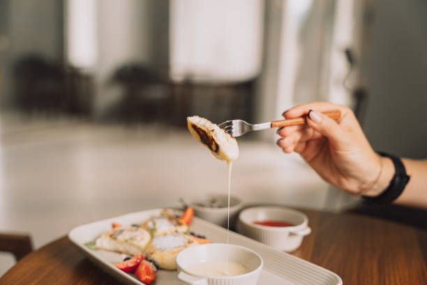 istock Cottage cheese pancake on forks with strawberries on rectangular plate with sauce on wooden table 2040015692