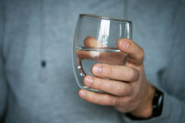 istock Man holds glass of clean water 2040021534