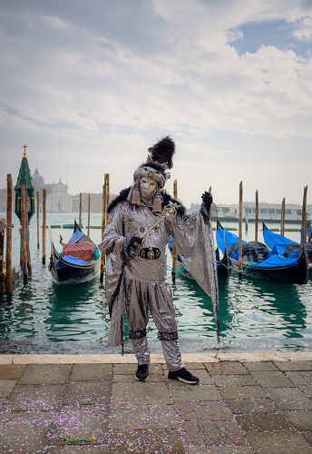 Venice, VE, Italy - February 13, 2024: couple of people with very elegant noble clothes from the last century masked during the Venetian carnival