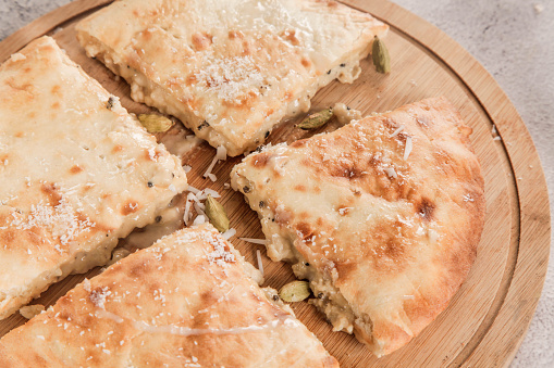 Sweet rabri stuffed naan, made in condensed milk with coconut toppings pistachio and cardamom.
