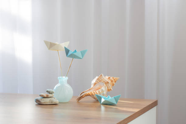 bateaux en papier dans un vase en verre avec décor de mer sur une table en bois - nautical vessel isolated toy boat wood photos et images de collection