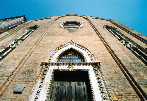 Venice, Veneto, Italy: San Gregorio Church, formerly part of a Benedictine abbey - first built in the 13th century, the current façade dates from the mid 15th century, designed by Antonio da Cremona in Gothic style, with an ornate ogival portal, elongated mullioned windows with ogival top and apse - Dorsoduro district.
