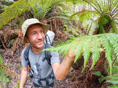 A man enjoys a scenic hike in Tasmania, immersing himself in the beauty of the natural surroundings.