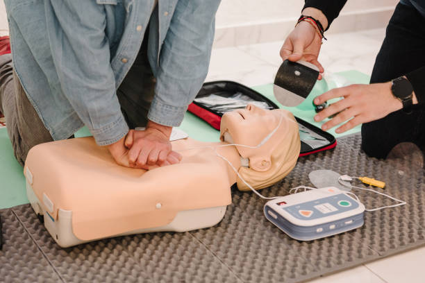 istock Indirect heart massage. Automated external defibrillator device, AED with training dummy mannequin. Use an automatic defibrillator in conducting basic cardiopulmonary resuscitation of victim. Closeup 2040090458