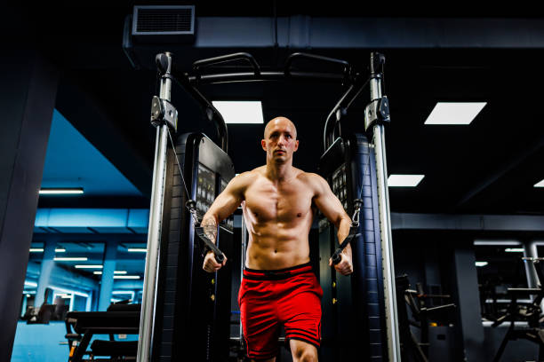 istock Man doing chests exercise with cables in the gym 2040108680