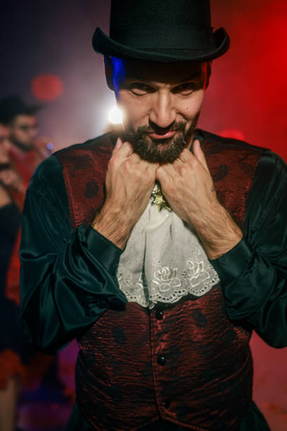 A young Caucasian man is dressed in a Georgian traditional clothing and a male headdress. The male dancer is showing a poses of folk dance. He is looking at the camera. Studio shooting