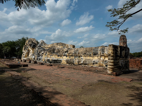 Giant stone Buddha statue in reclining position in the historical park of Ayutthaya, Thailand