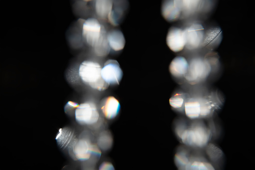 Optical effect from glass faceted beads on a black background.