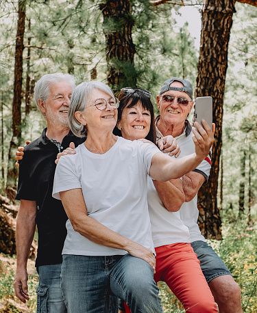 Group of Senior Friends Enjoying Trekking Day on Forest - Elderly Caucasian Men and Women Take Selfie with Smartphone - Freedom, Sport, Healthy Lifestyle Concept, Sport, Healthy Lifestyle Concept