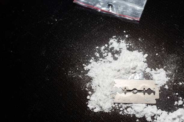 istock Razor Blade on drug powder,cocaine bag on reflection black background.Copy space. 2040126171