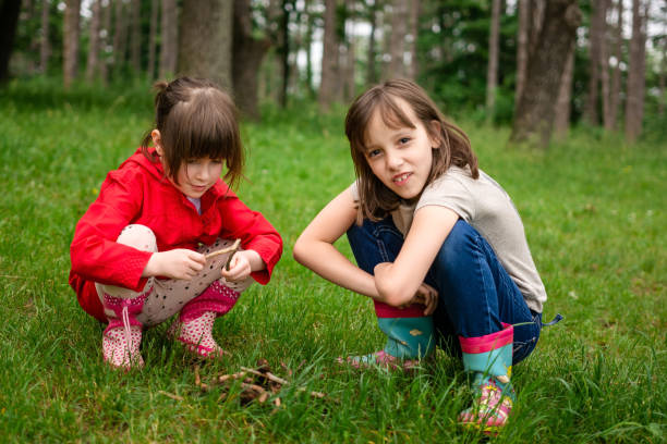 istock Two girls are collect branches for camping in the forest. 2040126721