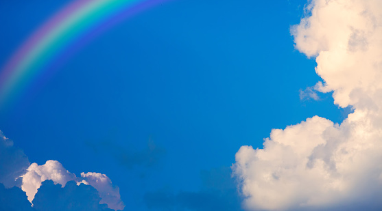 abstract blue sky background; rainbow and clouds