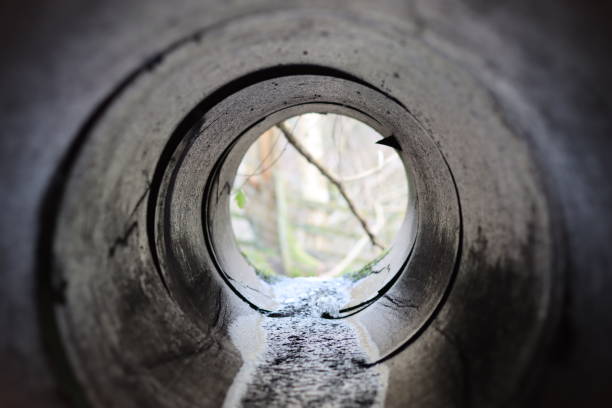 istock View through a round tunnel carrying a stream beneath a road 2040137180