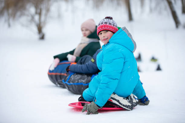 istock Children ride tubing down a snow slide. 2040179837