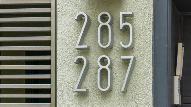 brass house number thirty seven on a plastered wall
