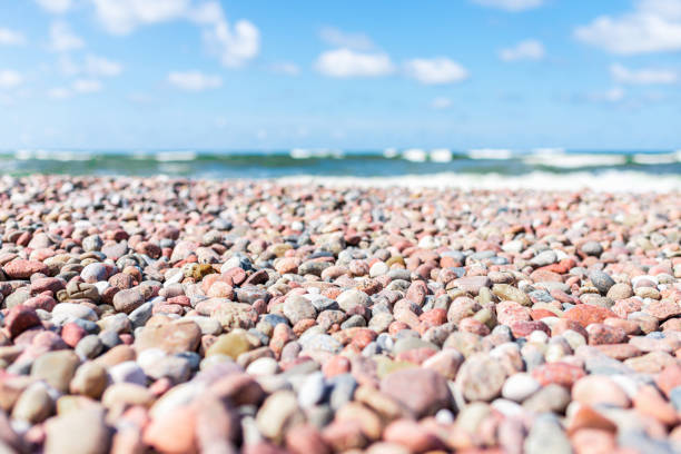 Small pebbles on the shore. sunny summer day blue sky,white clouds. beautiful lonely small pebble beach.Copy space.