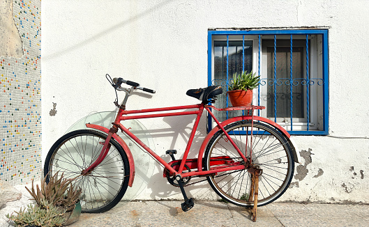 Red bicycle parked on sidewalk in Foca, Izmir