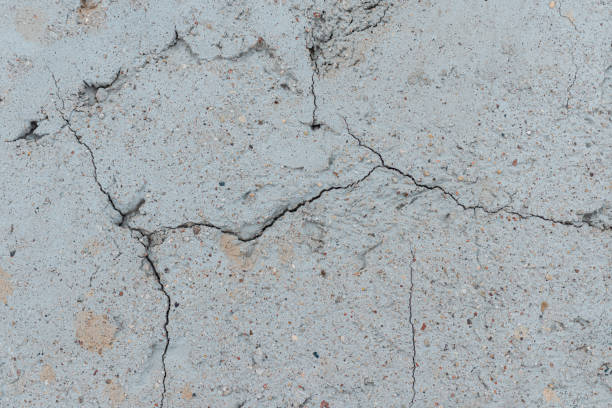 istock Cracked concrete wall gray cement surface background.cracked grey stone wall in winter.close-up. 2040222112