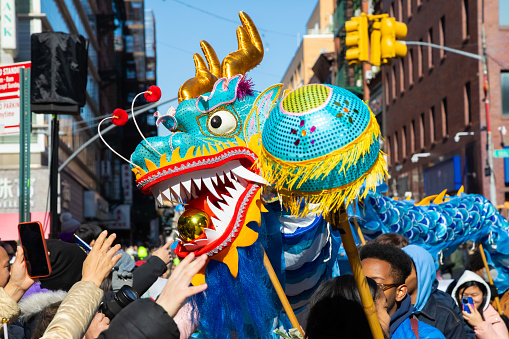 Crowds try to touch the blue and gold dragon as it makes it way down Mott St. in NYC's Chinatown during the annual Chinese New Year Parade, February 25, 2024.