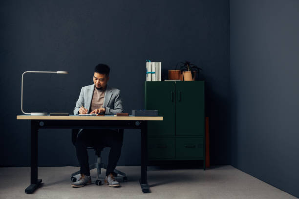 istock Focused Businessman Writing Notes at Modern Office Desk 2040236918