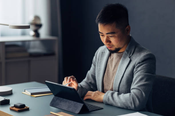 istock Professional Asian Man Using Tablet at a Modern Office Desk 2040236924