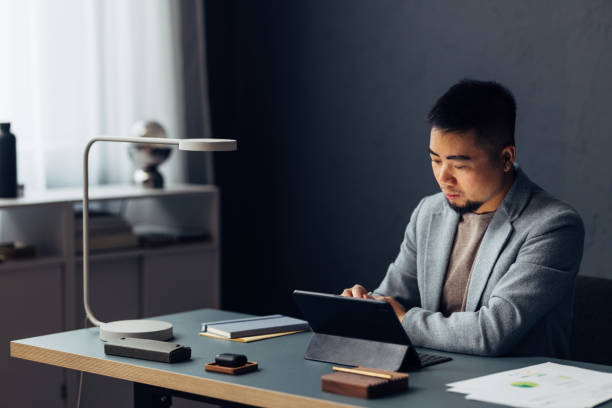 istock Focused Businessman Working on Tablet in Modern Office Setting 2040236930