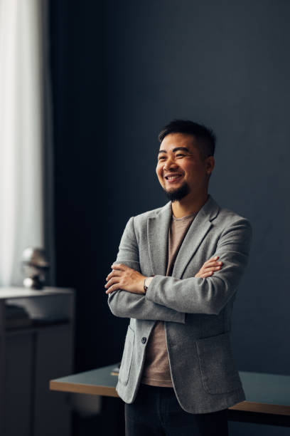 Confident Smiling Asian Businessman in Modern Office Setting