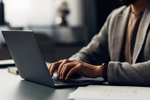 Close-up of professional's hands typing on a laptop keyboard, symbolizing business, technology and productivity in the workplace.