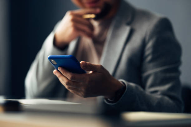 Businessman Evaluating Information on Smartphone in Office